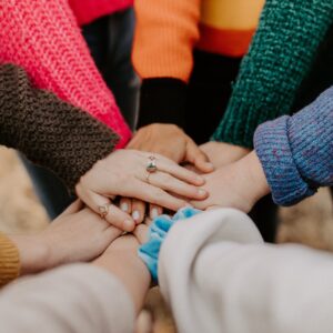 A group of hands stacked together, in a circle.