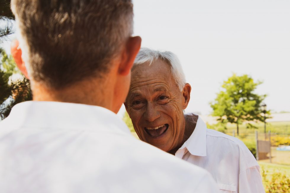 Senior man smiles as he looks at his nephew.