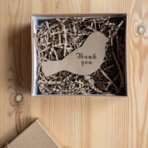 A gift box with a wooden bird and the words 'Thank You' written on it.